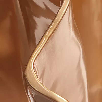 A close-up of a smooth, highly reflective copper surface with a glossy finish, showcasing Koket's Copper Chromium (Gloss) finish.