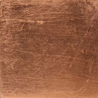 Close-up Copper Leaf: metallic surface in copper tones with fine irregular brushing lines, featuring a soft sheen.