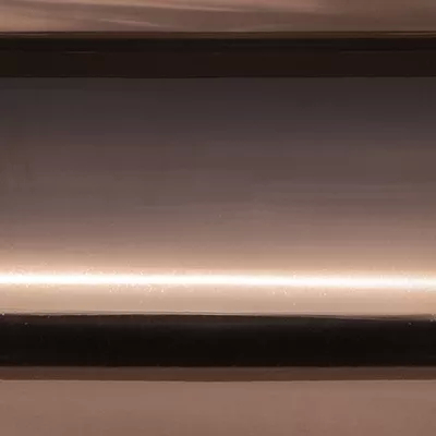 Close-up Copper Plated Brass (Gloss): smooth and shiny metallic surface in rosy copper tones, with soft reflections.