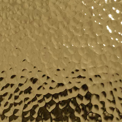Close-up Hammered Brass (Gloss): golden surface with an irregular hammered texture, featuring bumps and shiny reflections.