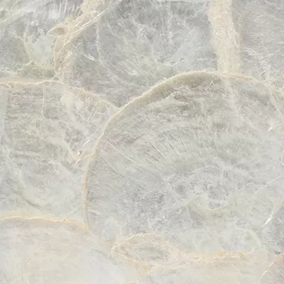Close-up Mother Of Pearl Ivory: iridescent surface in shades of white and cream with an organic pattern of overlapping layers, featuring a soft and pearlescent sheen.