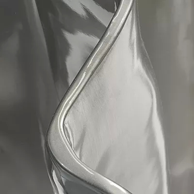 A close-up of a smooth, highly reflective silver surface with a glossy finish, showcasing Koket's Silver Chromium (Gloss) finish.