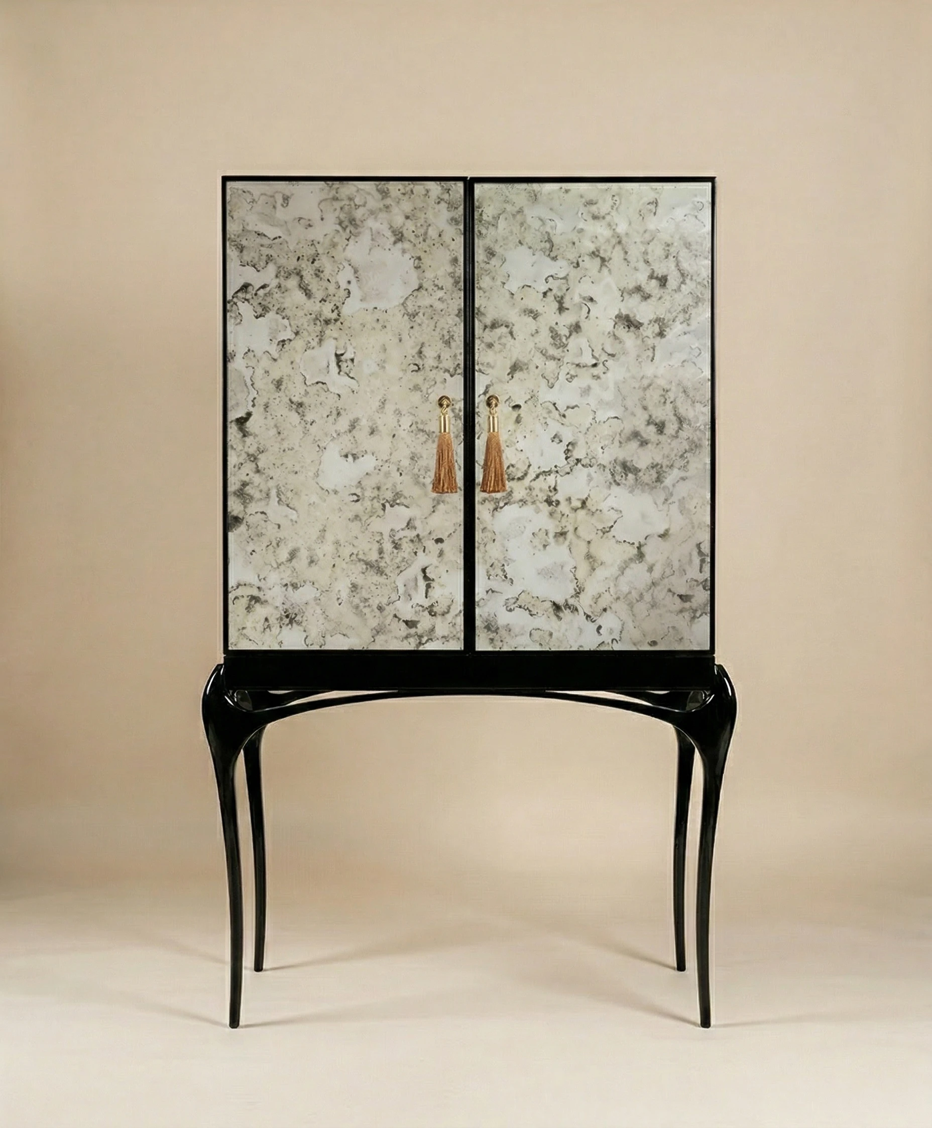 Temptation Aged Mirror Bar Cabinet with marble-patterned doors, black sculptural legs and gold tassel handles