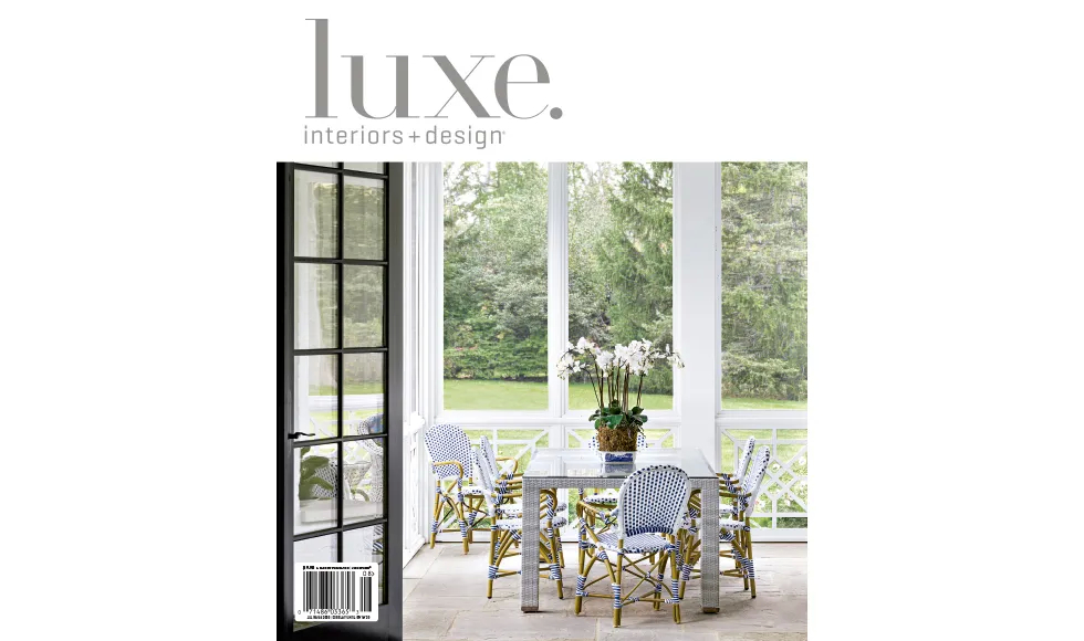 Luxe Interiors + Design magazine cover featuring an outdoor dining area with a glass table and patterned chairs.