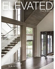 Elevated magazine cover showcasing a modern home interior with a grand staircase and large windows, by Yankee Custom Builders.