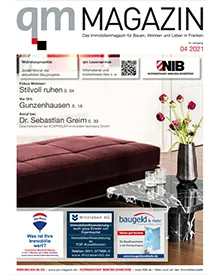 Cover of QM Magazin showing a modern living room scene with a burgundy sofa and a marble coffee table.