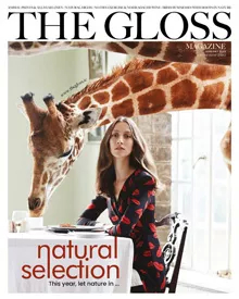 The Gloss Magazine January 2023 cover, featuring a woman in a patterned dress at a table with a giraffe behind her.