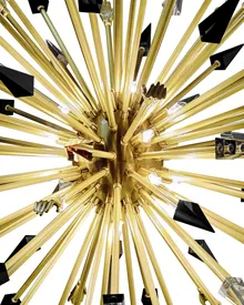 KOKET Outburst Chandelier—polished brass starburst with black accents and crystal details, featured in Lush Magazine as a bold luxury lighting statement.