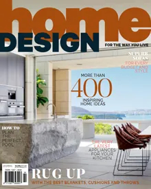Home Design Magazine cover featuring a modern kitchen with a stone island and an ocean view.