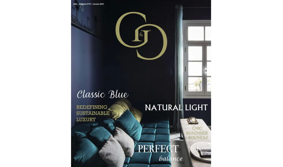 G&G magazine cover with a classic blue room featuring a teal sofa and natural light from a window.