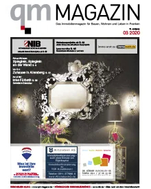 Press clipping of QM Magazin cover with an ornate mirror, a lamp, and flowers in a dark room.