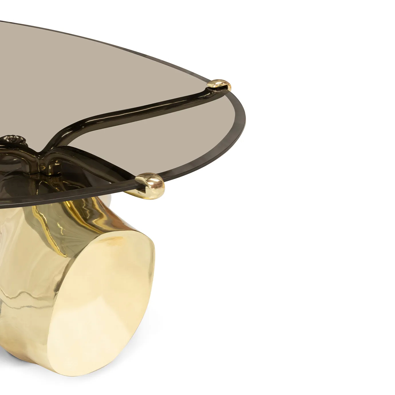 The Tabu Polished Brass Coffee Table has an oval glass top resting on a unique, artistic brass sculpture of a figure.