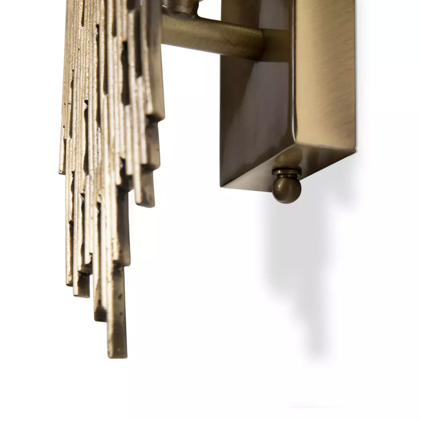 Elegant close-up of the textured golden-toned metallic structure detail of the Vivre Sconce attached to a rectangular base.
