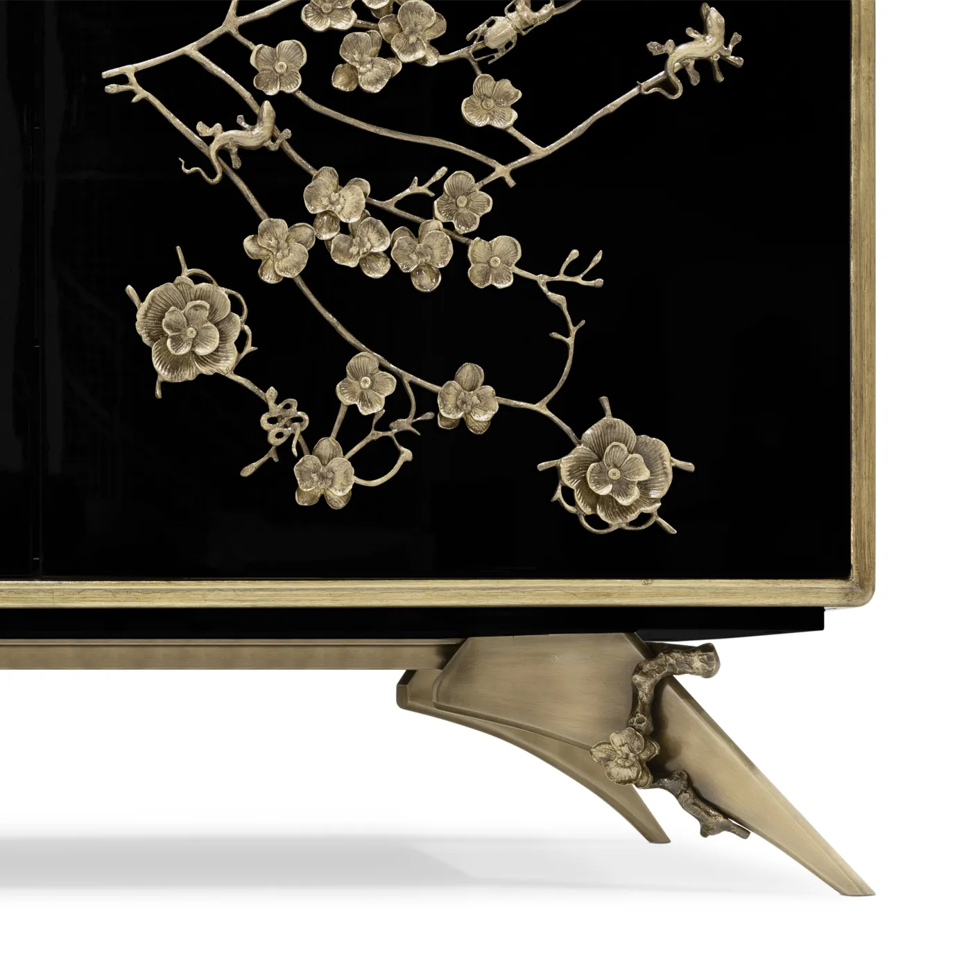 Detailed view of the base of the Spellbound Lacquer Armoire, displaying the golden floral themed features on the bottom as in doors.