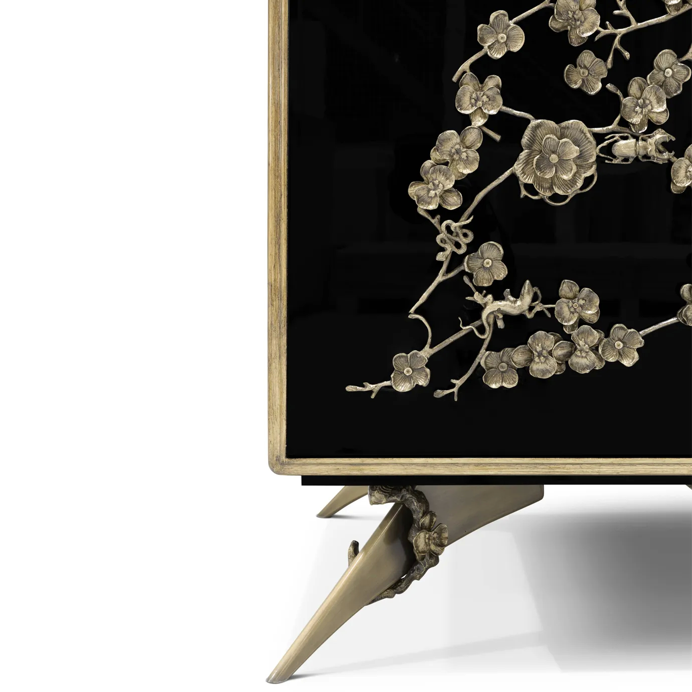 Detailed view of the base of the Spellbound Lacquer Armoire, displaying the golden floral themed features on the bottom as in doors.