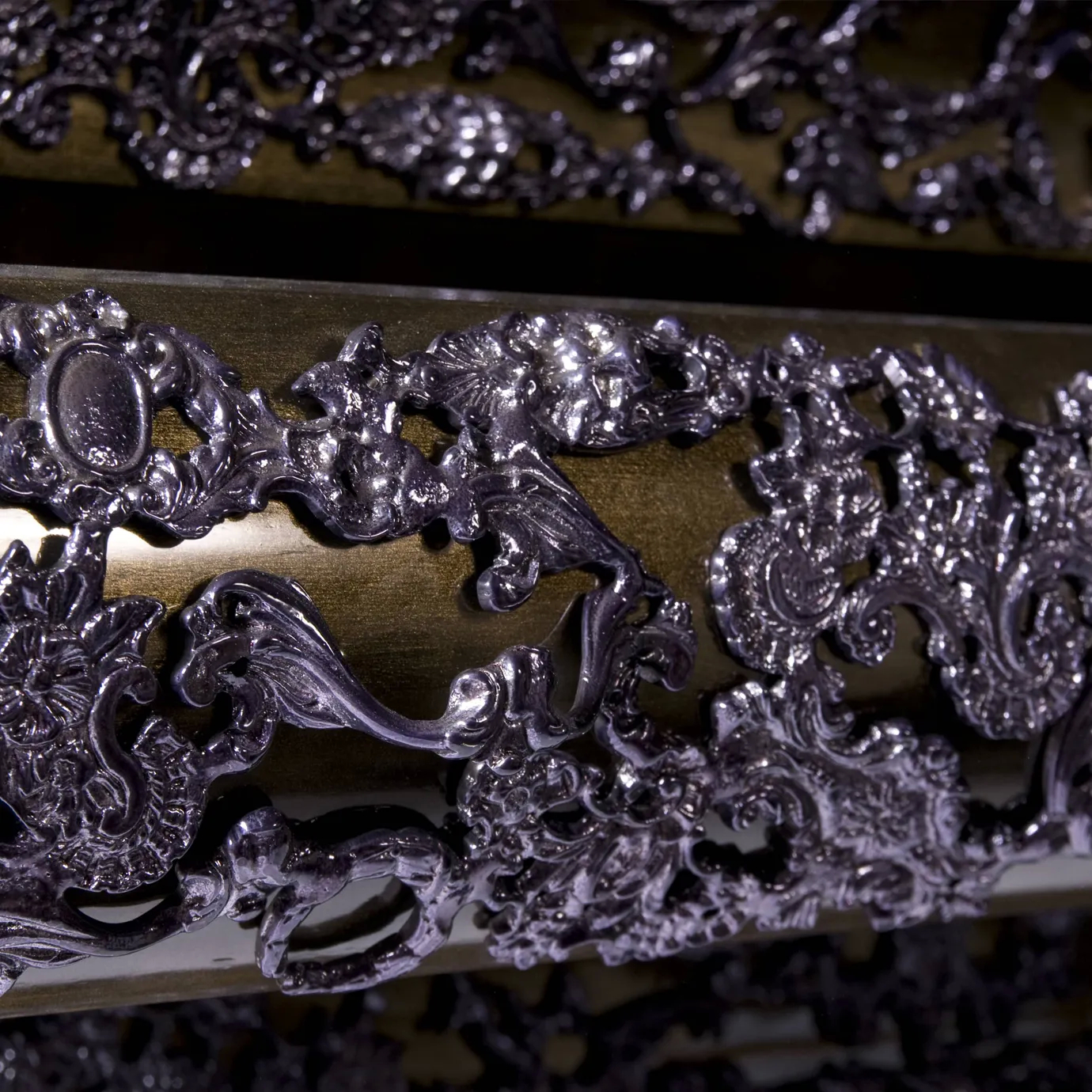 Close-up of gold drawer with hammered metal texture, crochet-inspired pattern, and sleek gold handle.