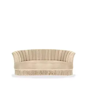 Elegant Sevilliana Sofa upholstered in cream fabric with pleated details on the backrest and a long fringe at the base.
