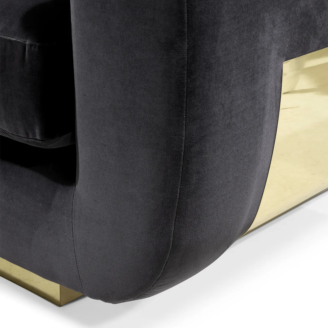 A close-up of the Sofia Sofa highlights the plush black velvet upholstery and the sleek, shiny gold detail on its side.