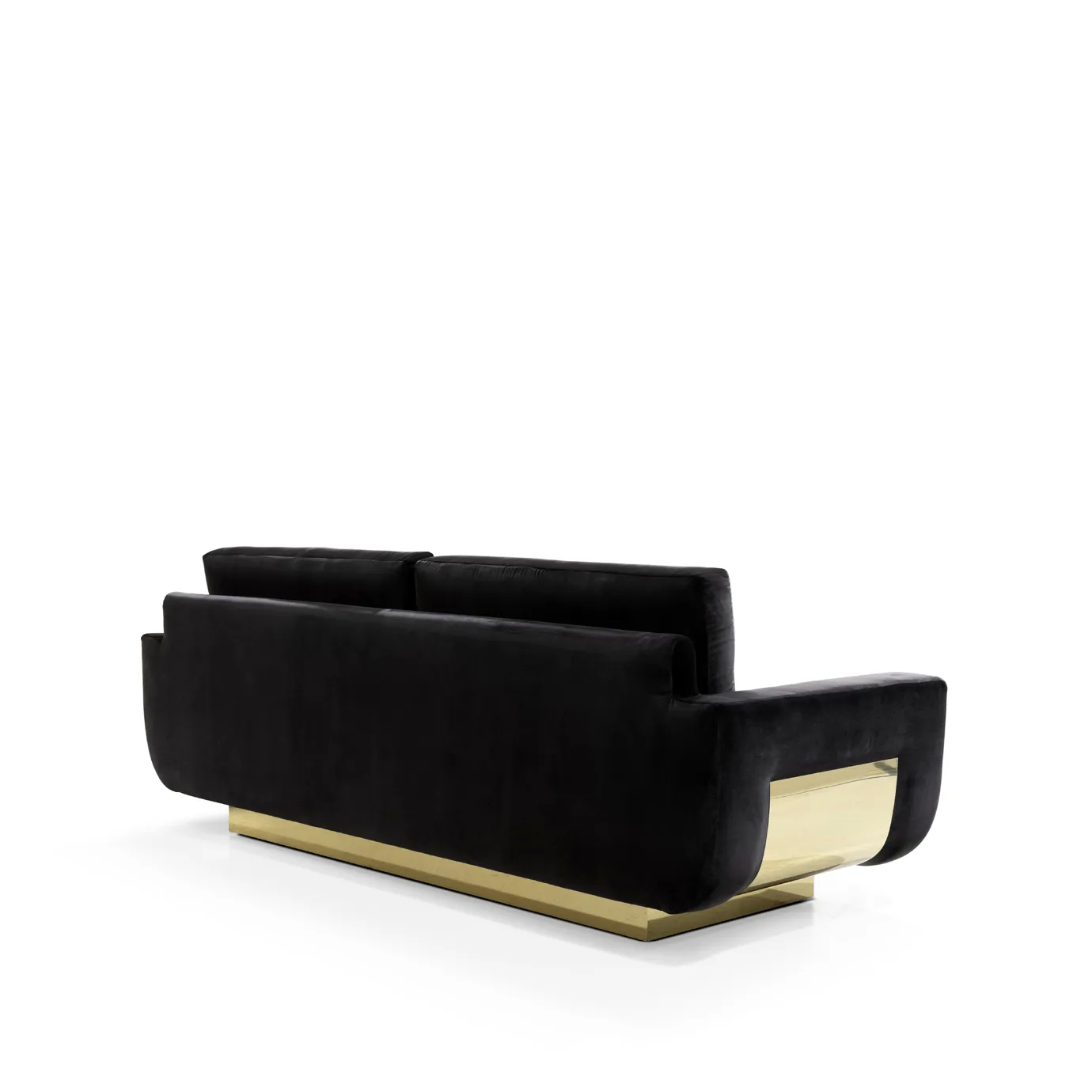 An angled view of the back of the luxurious Sofia Sofa by Koket, featuring its sleek black velvet upholstery and statement gold base detail.