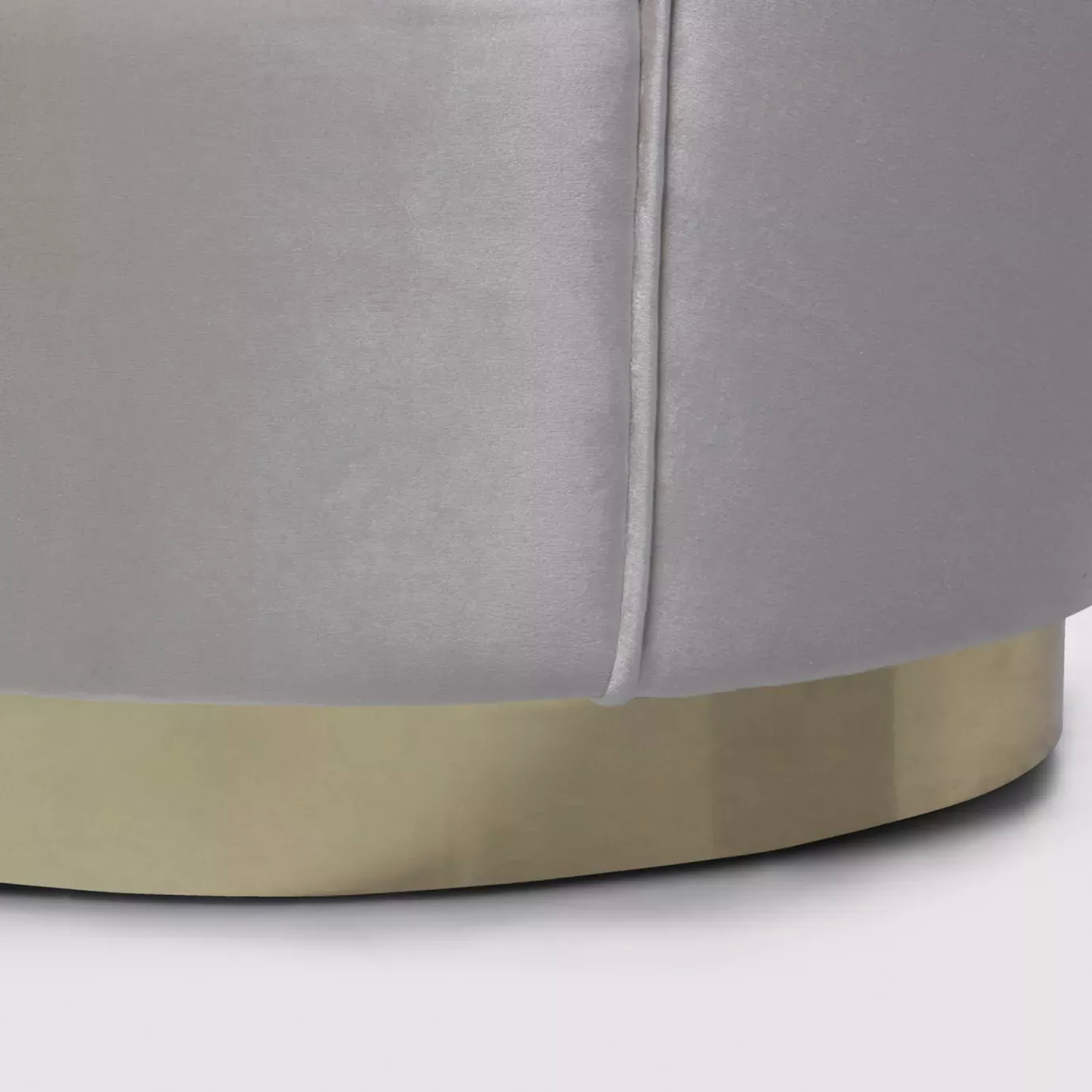 Elegant close-up of the golden metal base and the white fabric upholstery with pleated details of the Besame Sofa.
