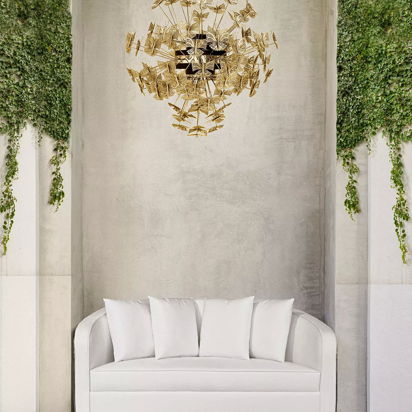 An outdoor setting with a nature-inspired Enchanted Sofa in middle, with its intricate structure resembling branches combining with the white upholstery. Above the sofa, there is a golden chandelier.