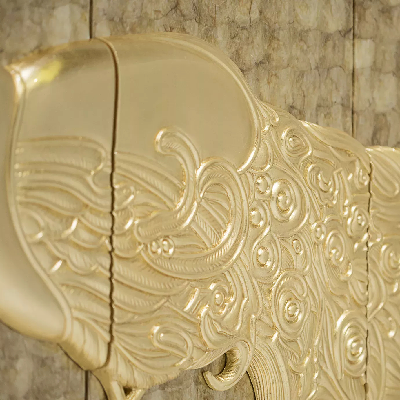 Elegant detail of the golden peacock pattern on the Camilia cabinet.