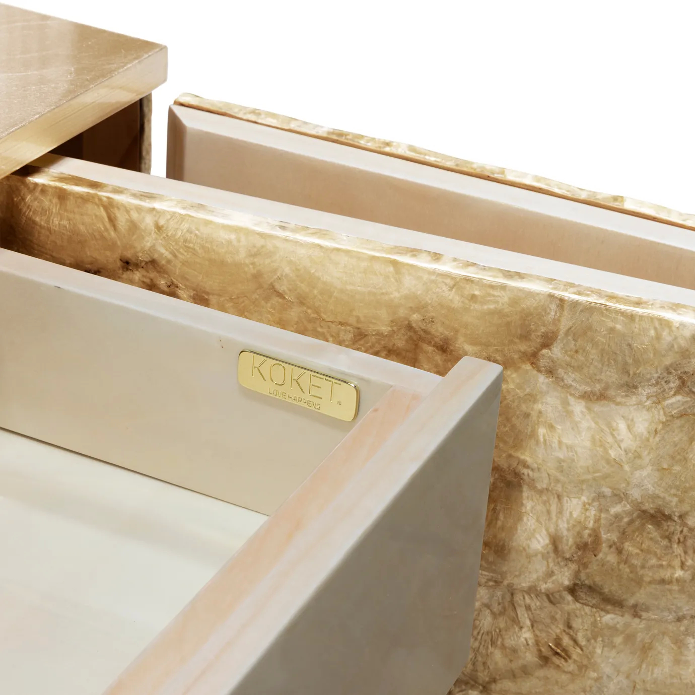 Detail of the Camilia cabinet drawer with golden "KOKET" plaque.