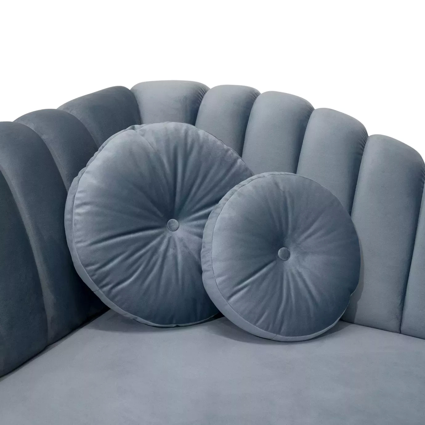 Elegant close-up of the blue velvet upholstery with pleated details and round pillows of the Millicent Chaise