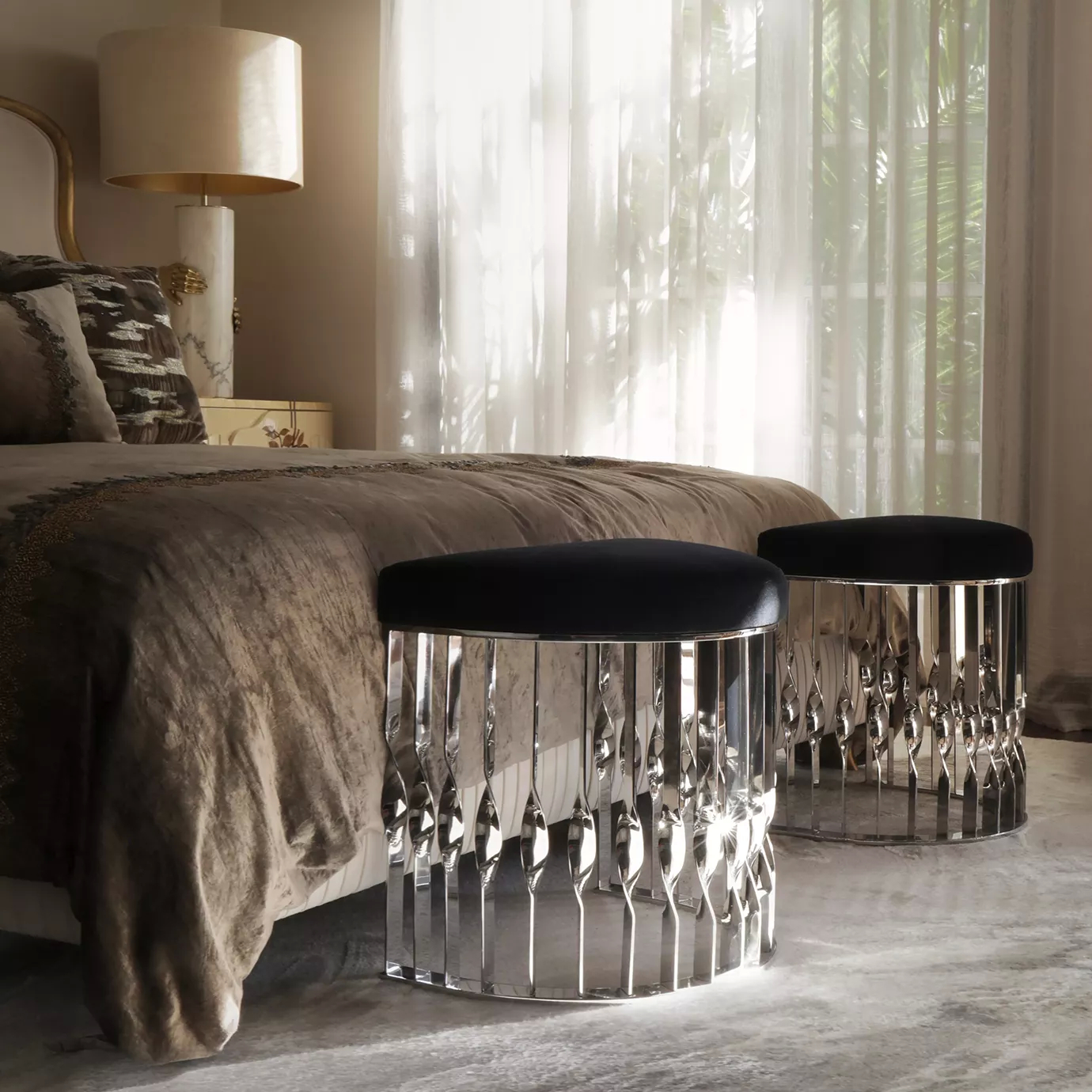 Elegant bedroom with two Mandy Stools featuring black velvet seats and sculptural silver bases beside a sophisticated bed.