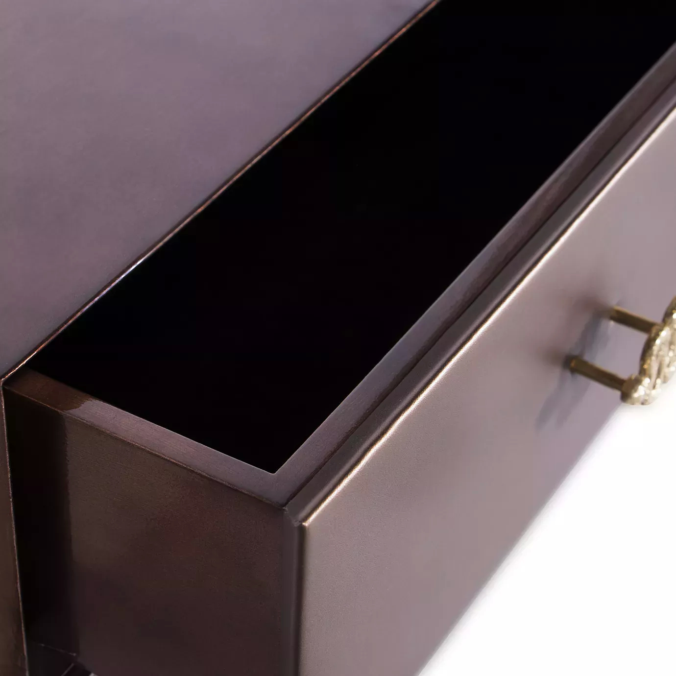 Detail of the open drawer of the Untamed Console with golden handle.