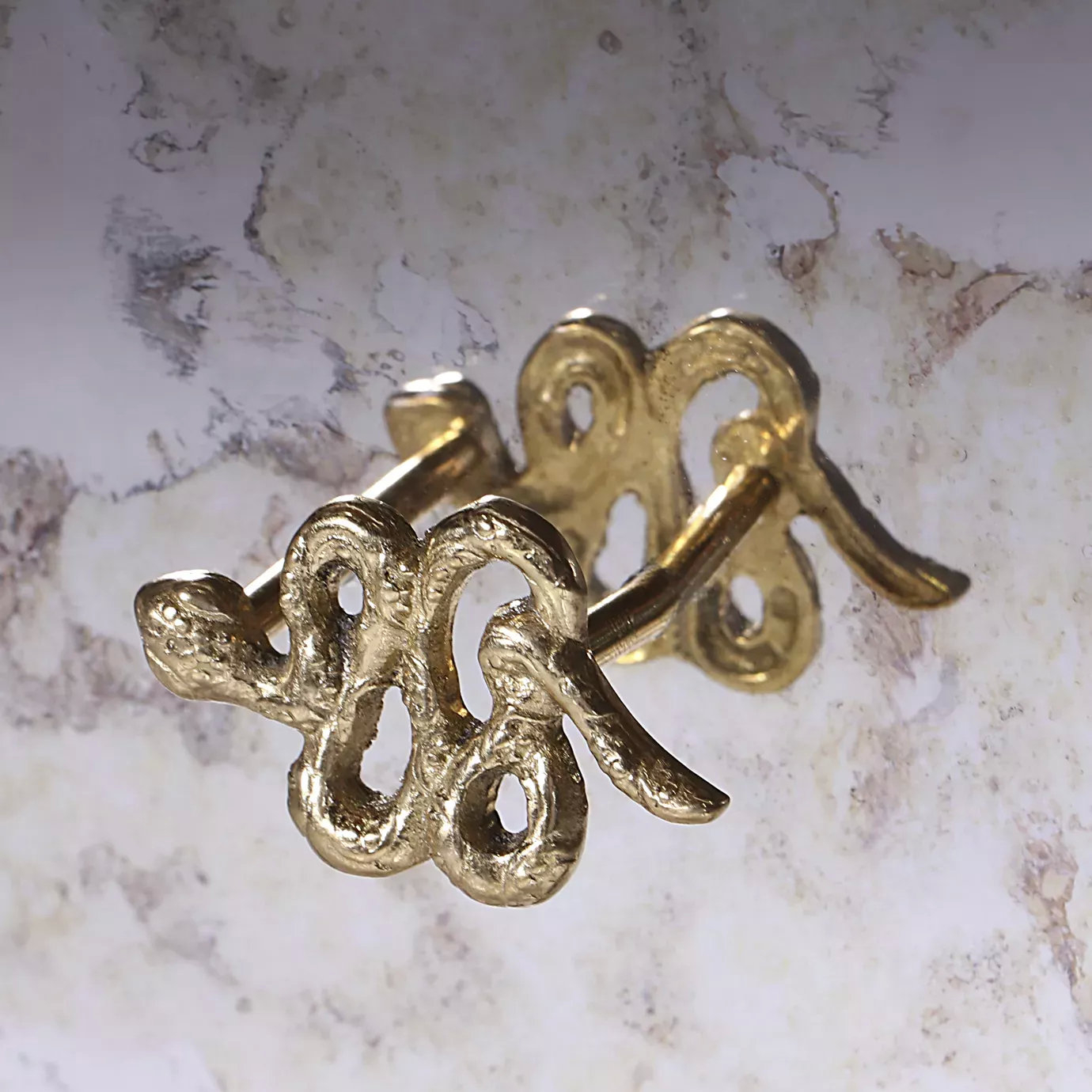 Detailed close-up of the elegant golden snake handle of the Untamed Console.