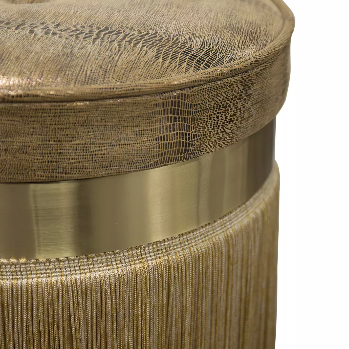 Elegant close-up of the textured leather seat detail in golden tones and the golden band of the fringed base of the Isabella Stool.