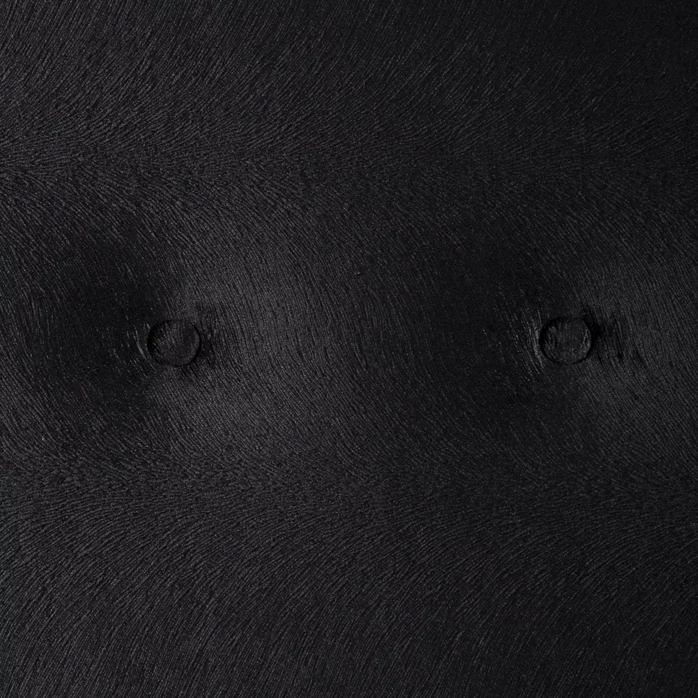 Elegant close-up of the black velvet upholstery detail with buttons on the headboard of the Alexia Bed.