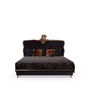 Elegant Forbidden Bed with black velvet headboard featuring sculptural golden details and crystal applications, dark bedding, and decorative pillows.