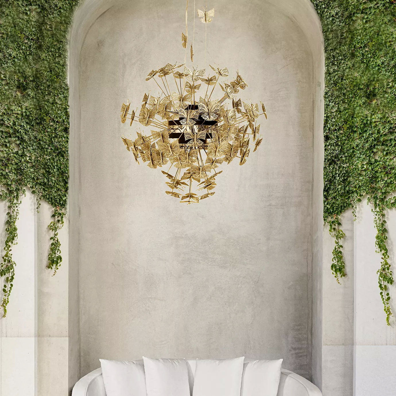 Outdoor space with a white sofa in the center and a Nymph Chandelier, inspired by butterflies, with multiple representations of the delicate animal hovering in the air.