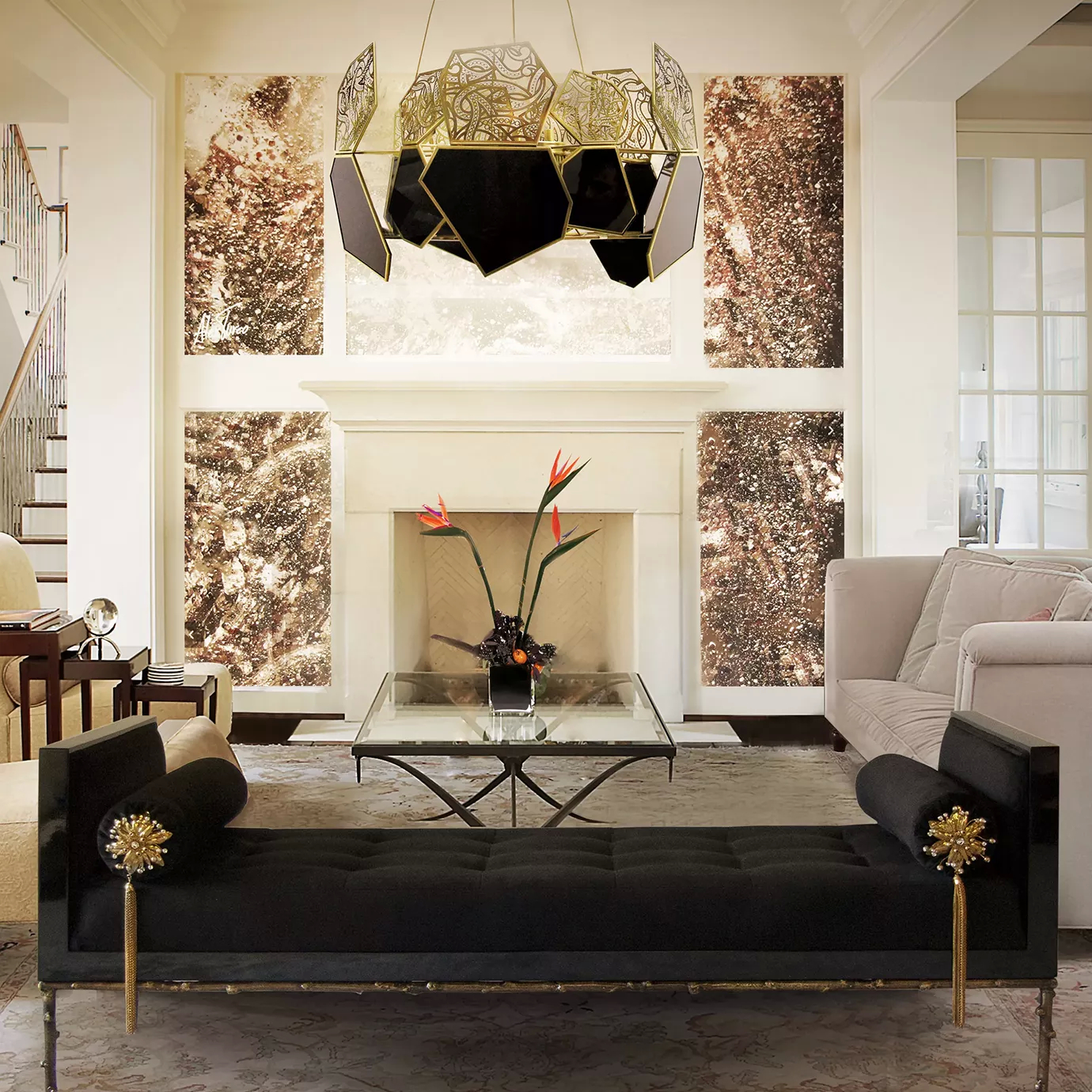 Elegant living room with a black daybed featuring golden accents and cylindrical pillows, a glass coffee table with a dark base, and the Hypnotic Bronze Glass Chandelier suspended above.
