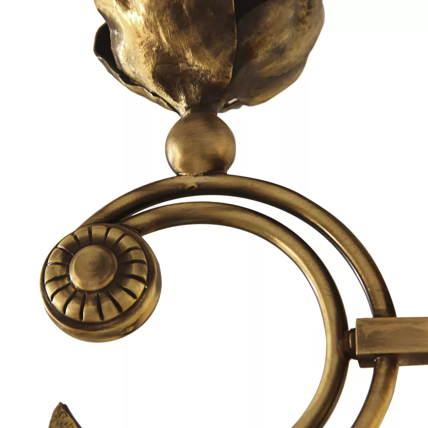 Elegant close-up of the spiral decorative element detail with a floral center of the golden Flora Sconce.