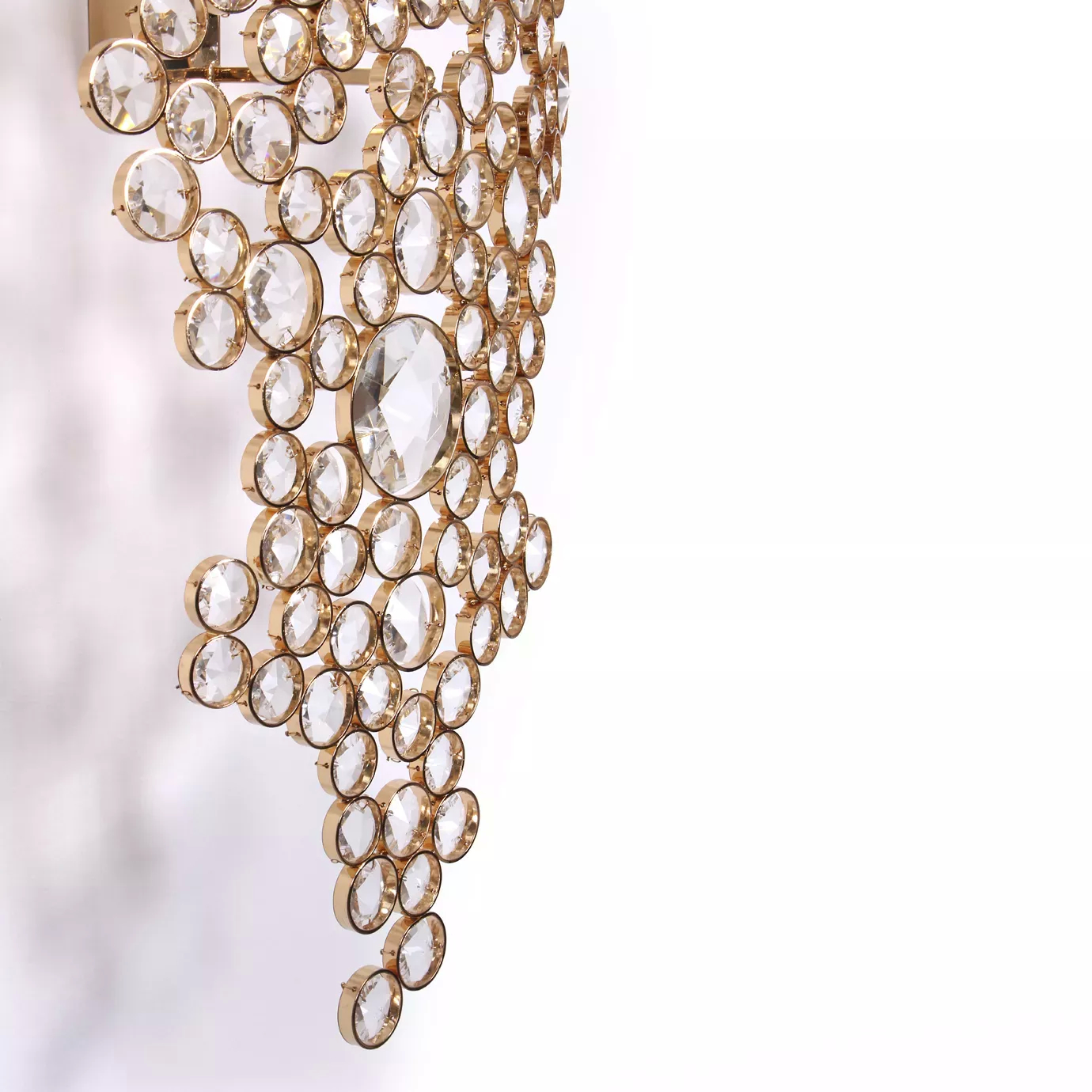 Elegant close-up of the detail of the faceted clear crystals of varying sizes fixed to the golden frame of the Eternity Sculpture.