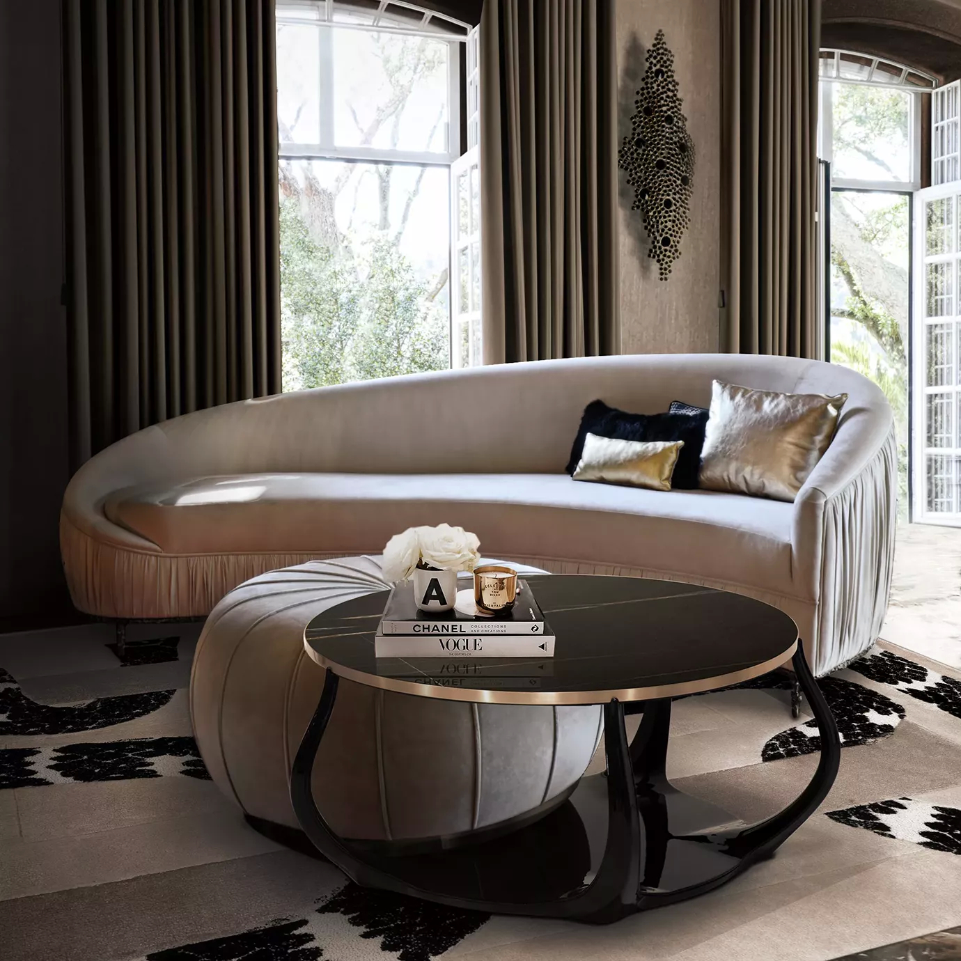 Elegant living room with a curved light-toned sofa with decorative pillows, a light round ottoman serving as a base for a round coffee table with a Sahara Noir black marble top and golden details, under the golden and shiny Eternity Sculpture mounted on the grey-toned textured wall.