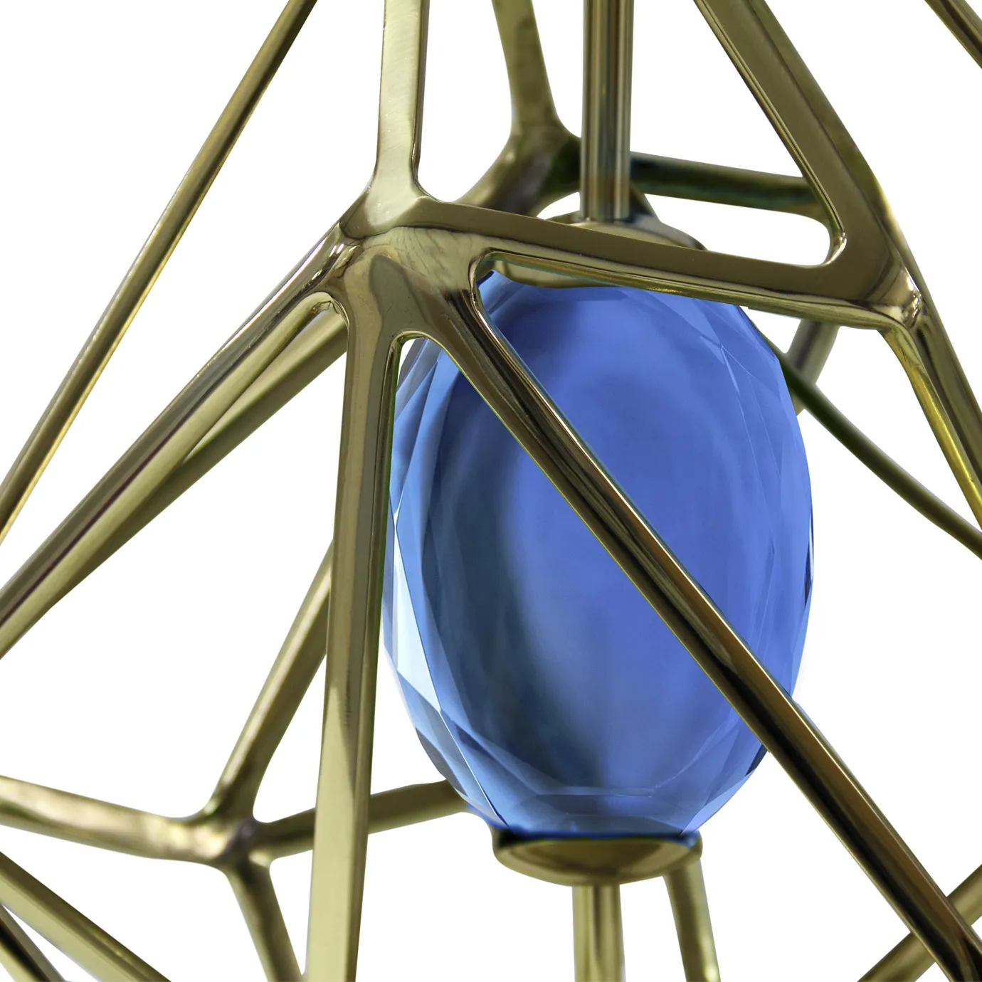 Elegant close-up of the faceted blue glass element detail enclosed by the geometric golden structure of the Gem Table Lamp.