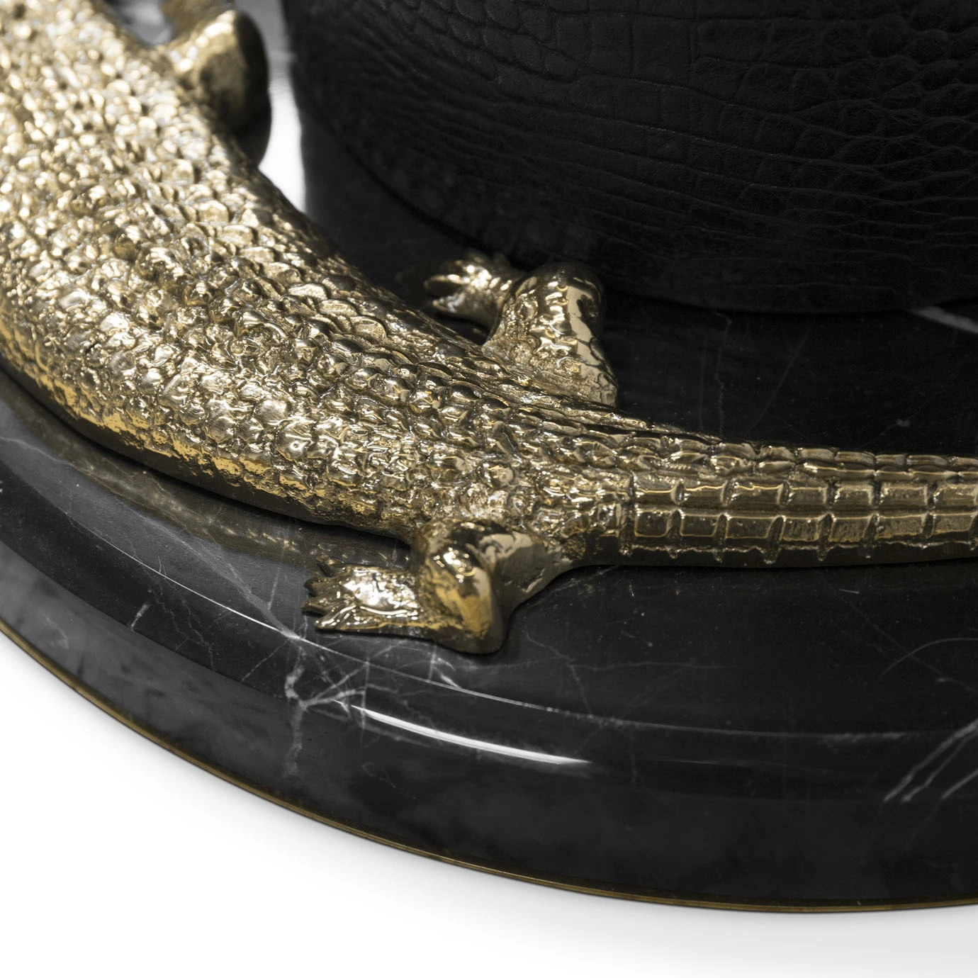 Elegant close-up of the sculptural golden crocodile detail with intricate texture on a round black marble base with white veins, at the bottom of the Reptilian Table Lamp.