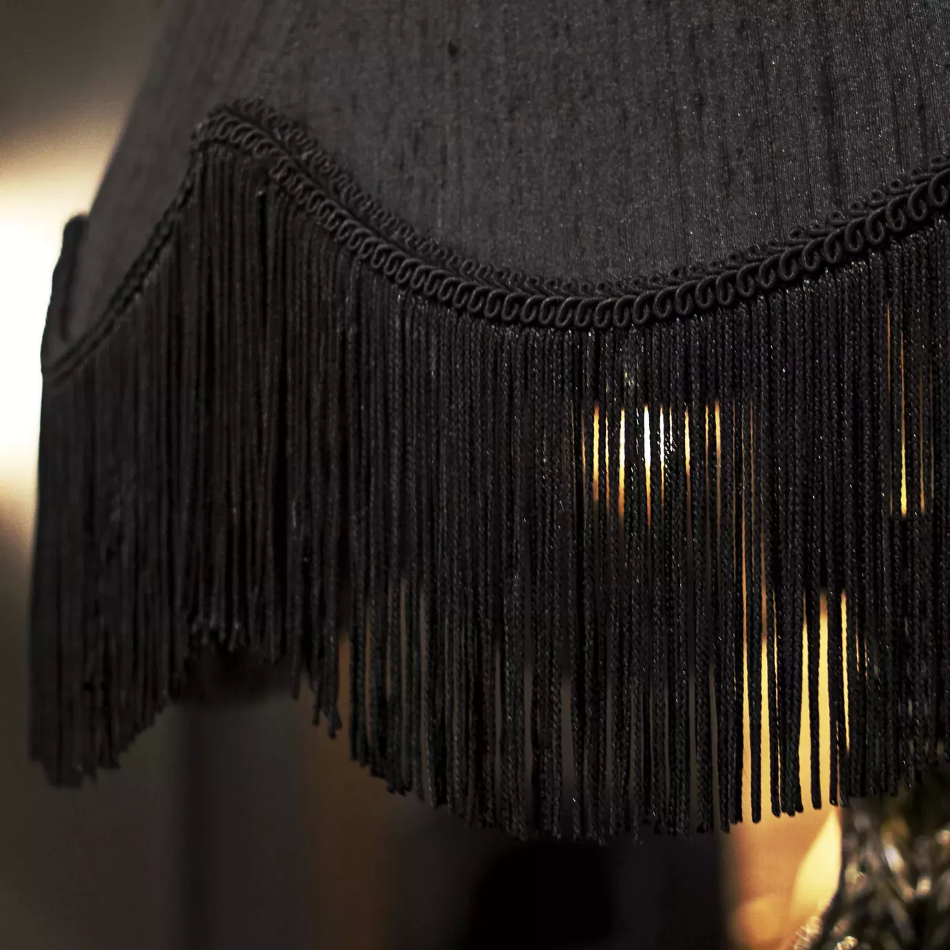 Elegant close-up of the illuminated black lampshade texture and fringe detail of the Lotus Floor Lamp.