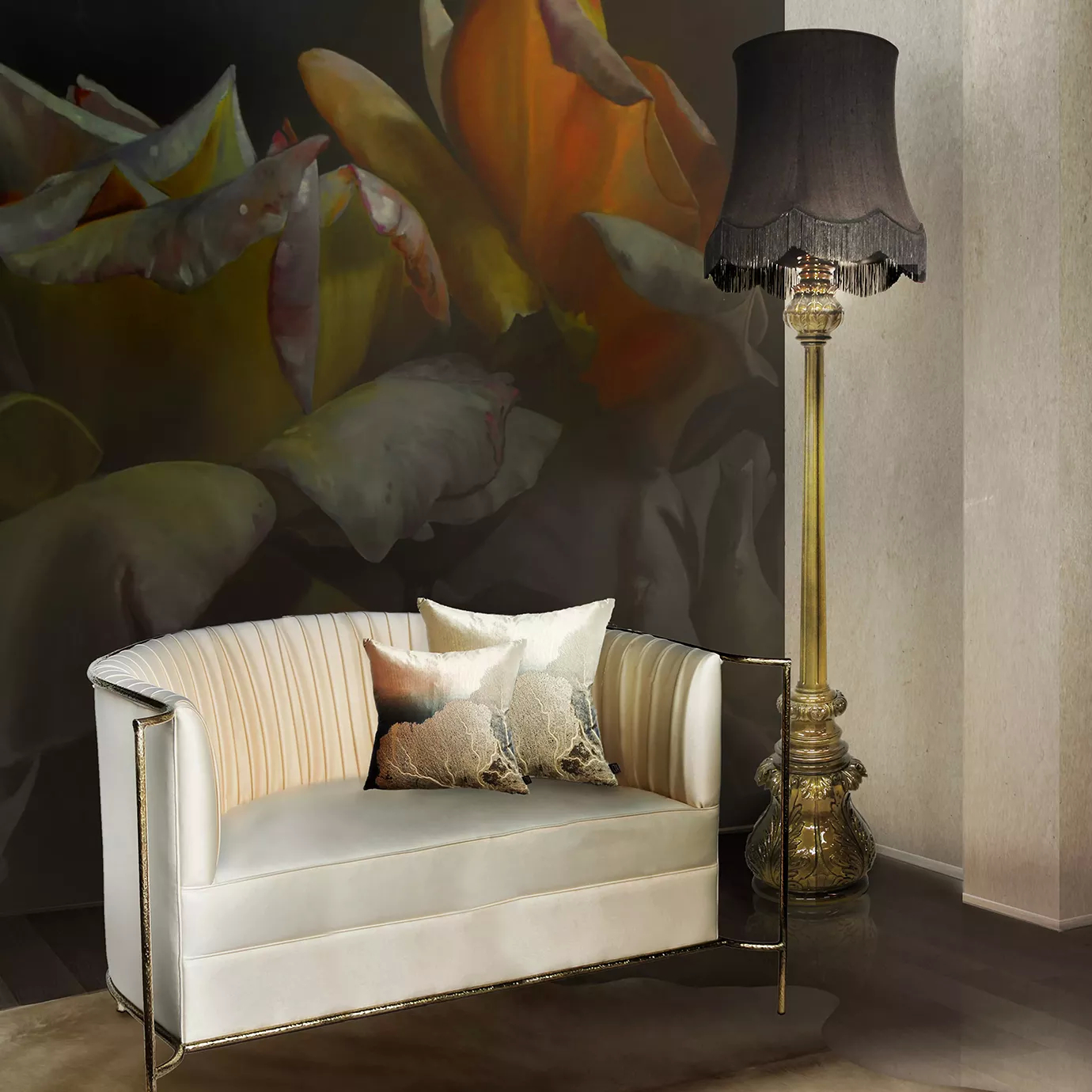 Elegant corner with the Desire Sofa in white velvet with golden details and decorative pillows, and the Lotus Floor Lamp with an ornate golden-toned base and a grey fringed lampshade, on a dark floor and against a wall with an artistic floral mural.