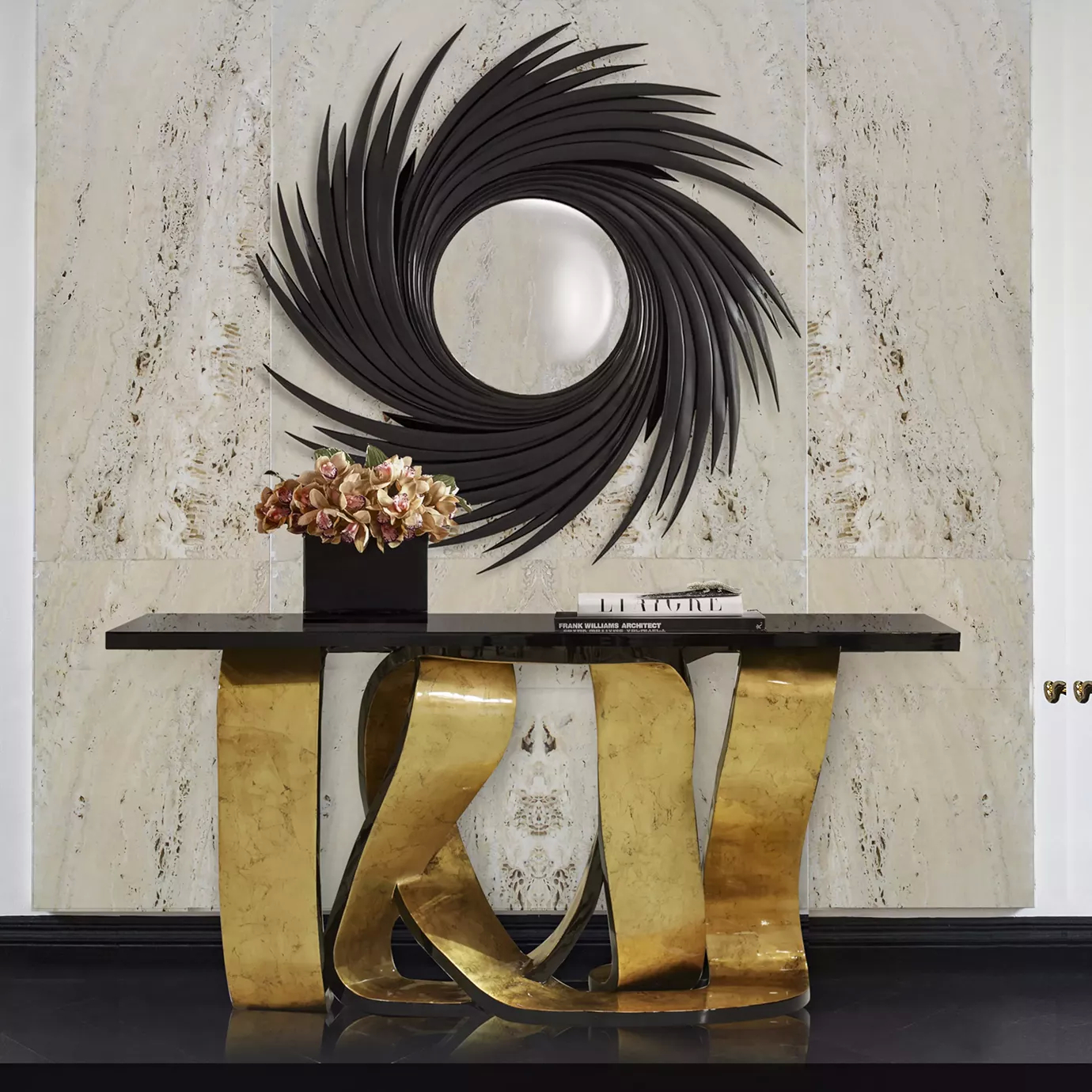 An entryway with a luxurious Ribbon Broken Gold Leaf Console, with a distinctive golden base, characterized by its twists and turns, and a black tabletop. Above the console, there is a mirror with a black frame.