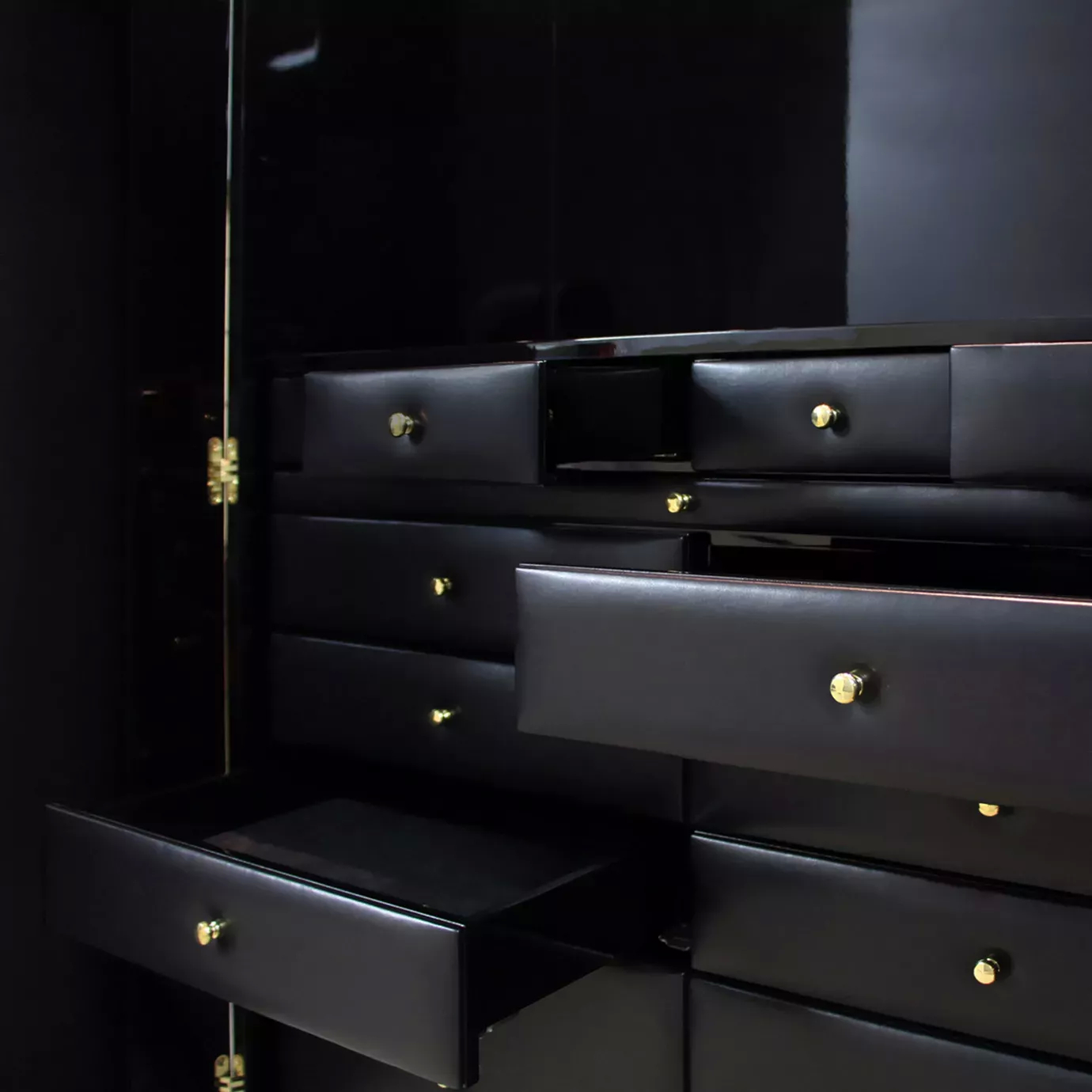 Interior of luxury Parisian armoire with elegant black drawers and gold accents