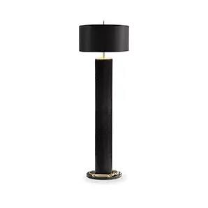 Elegant Reptilian Floor Lamp with a textured black cylindrical base featuring sculptural golden details at the bottom and top, and a black cylindrical lampshade.