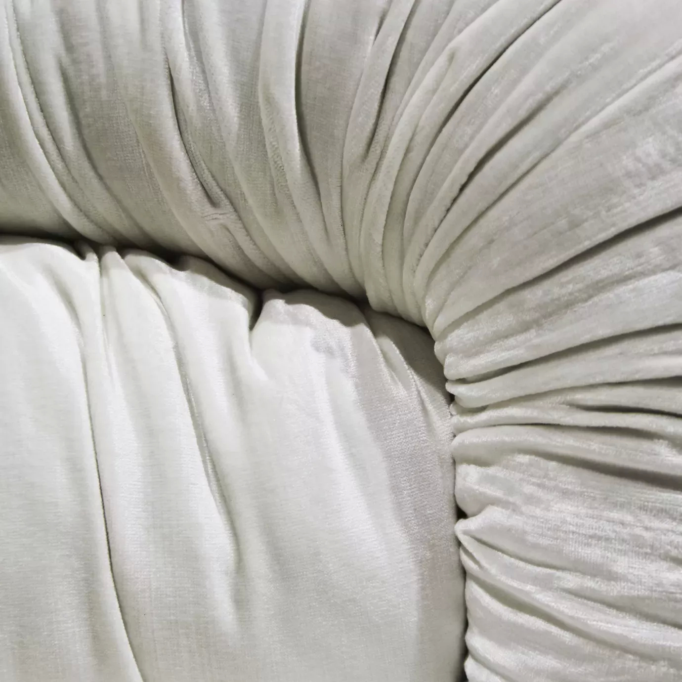 Elegant close-up of the soft white fabric detail with the ruched folds of the Cocktail Armchair.