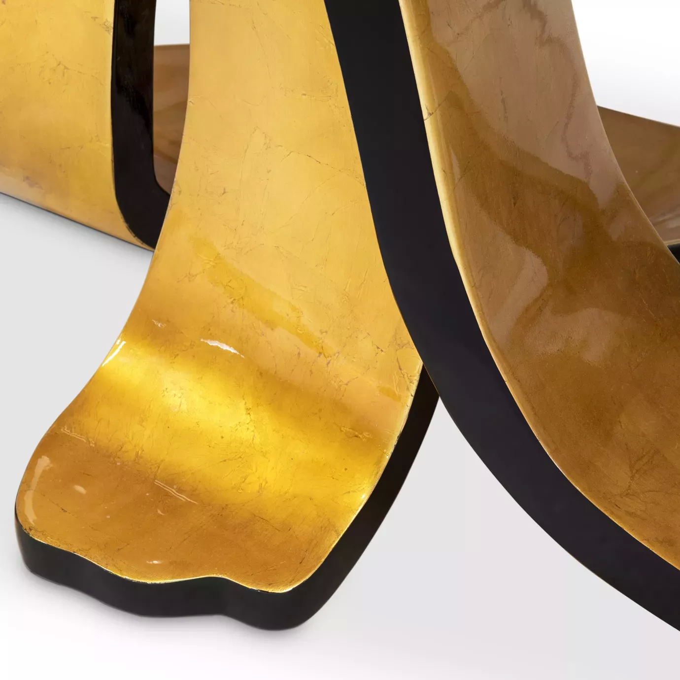 Elegant detail of the sculptural golden base of the Ribbon Broken Gold Leaf Dining Table