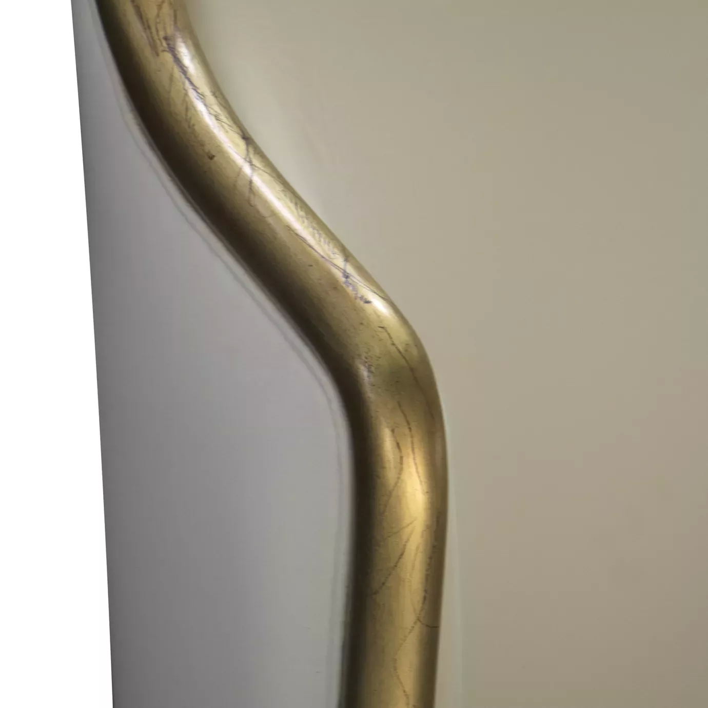 Elegant close-up of the curved golden trim detail of the white fabric upholstered headboard of the Forbidden Plain Bed.