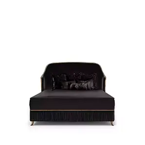 Elegant Forbidden Plissé Bed with a headboard and frame upholstered in soft black fabric with golden trim along the edges, adorned with black cushions and a pleated detail on the base.